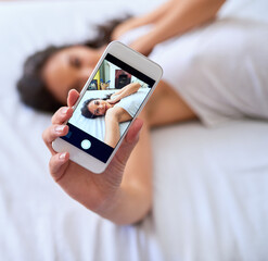 Phone screen, selfie and woman on bed in home for relaxing, calm and resting in morning on weekend. Comfy, tech and female person with photography app for picture on smartphone in bedroom at house.