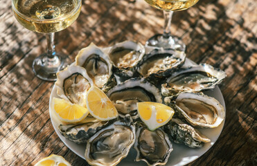 Fresh Oysters with champagne close up top view, over wood background, open french Fine de Claire...