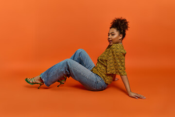 Stylish African American woman sitting gracefully with crossed legs.