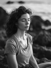 A black and white photo of a woman in meditation pose, looking peaceful and focused
