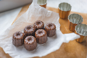 Caneles de bordeaux - traditional French sweet dessert with table background,Cannelés Recipe,small pastry rum and vanilla on a wooden plate,close up,french food,french cuisine,French Tourism,olympic