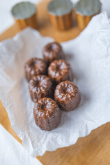 Caneles de bordeaux - traditional French sweet dessert with table background,Cannelés Recipe,small pastry rum and vanilla on a wooden plate,close up,french food,french cuisine,French Tourism,olympic