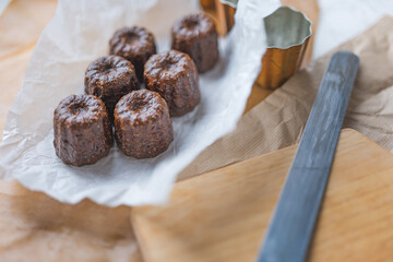 Caneles de bordeaux - traditional French sweet dessert with table background,Cannelés Recipe,small pastry rum and vanilla on a wooden plate,close up,french food,french cuisine,French Tourism,olympic