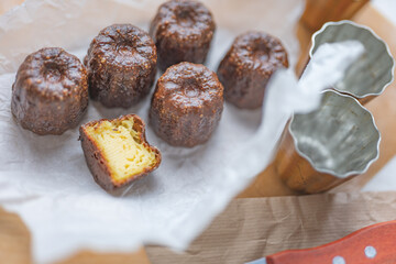 Caneles de bordeaux - traditional French sweet dessert with table background,Cannelés Recipe,small pastry rum and vanilla on a wooden plate,close up,french food,french cuisine,French Tourism,olympic
