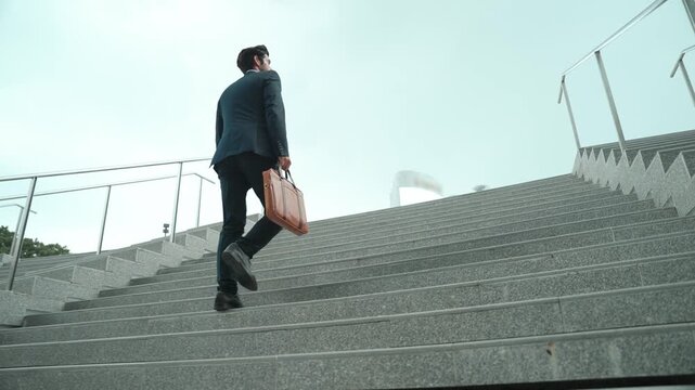 Top view of smart business man walking up stairs with bag in the hand. Professional project manager climb up the stair and going to workplace. Increasing skill, getting promotion, traveling. Exultant.