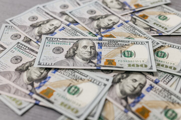 American hundred dollar paper money lies on the office table. Close-up of 100 American dollar bills. Currency exchange one hundred dollars. Investment, finance and income concept.