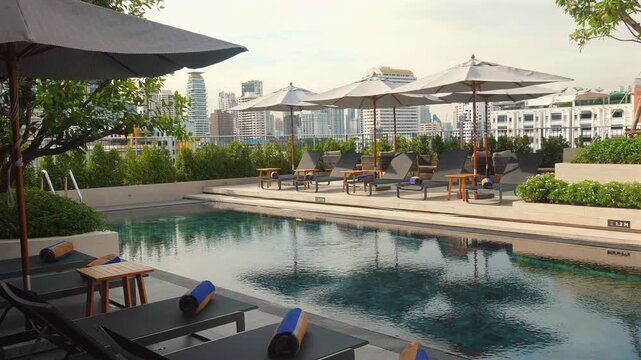 Luxurious rooftop swimming pool with sun loungers and umbrellas overlooking cityscape, perfect for relaxation and leisure. Urban Recreation and Relaxation.