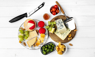 Different kinds of cheese served with green olives, tomato and grape for gourmet nutrition. Organic parmesan and brie delicatessen