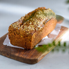 Whole Grain rye bread with seeds on a cutting board. Dark background.
