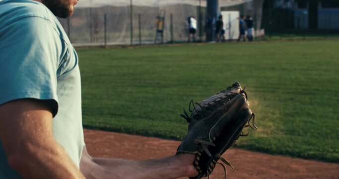 Super slow motion of baseball player practice with ball during workout before competition game match on baseball stadium on sunset at 1000 fps.