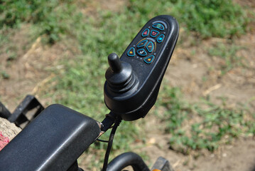 hand control panel for electric wheelchair. joystick and buttons for controlling a wheelchair on a blurred background. selective focus © Dmytro