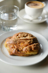 Cup of coffee and pastries on a minimalist coffee shop table. Coffee shop lifestyle. Selective focus.