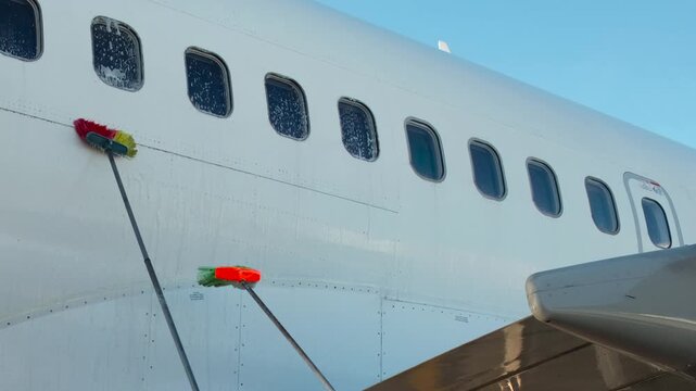 Plane Washing Cleaning. Passenger jet gets rid of dirt. Airport workers wash big passenger jet with water and brush