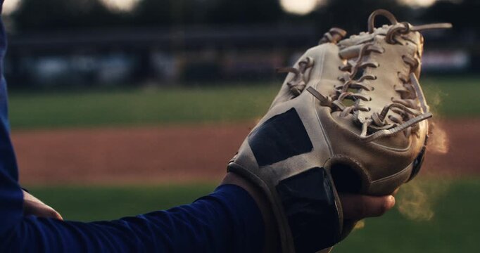 Super slow motion macro of baseball player practice with ball during workout before competition game match on baseball stadium on sunset at 1000 fps.