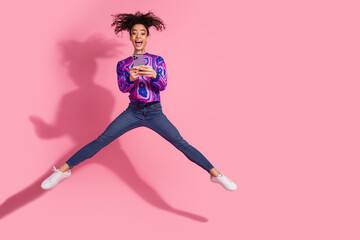 Full length photo of shiny attractive lady dressed purple sweatshirt jumping typing modern device...
