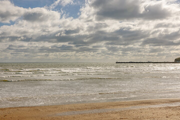Seascape showing cloudy sky above sea, space for text, winter sunny day, UK England