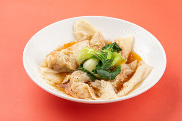 Portion of appetizing asian wonton dumplings with bok choi