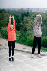 in the park a young couple in love doing sports couples warming up healthy lifestyle synchronized...
