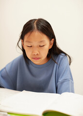 Naklejka premium 夏休みの小学生の女の子が家で宿題をする姿