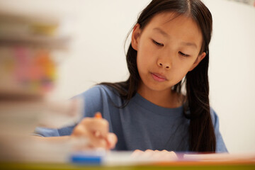 夏休みの小学生の女の子が家で宿題をする姿