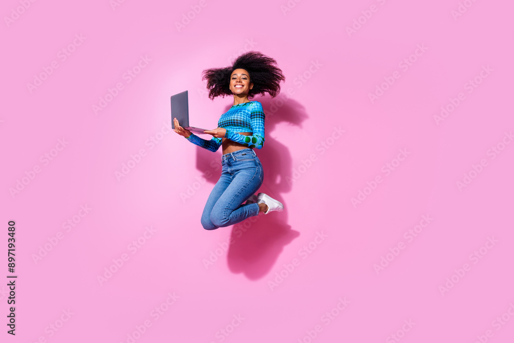 Poster Full size photo of lovely young lady jumping hold netbook dressed stylish blue garment isolated on pink color background