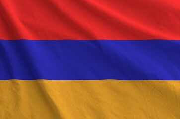 Armenia flag depicted on folded wavy fabric of old cloth close up