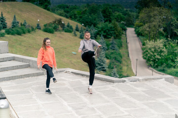 Fototapeta premium in the park a young couple in love doing sports couples warming up healthy lifestyle synchronized movements