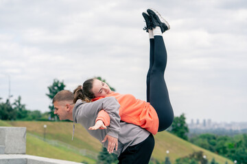 Fototapeta premium close up in the park a young couple in love doing sports couples warming up healthy lifestyle synchronized movements