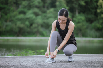 A young woman jogs in the city on a summer morning, embodying an active lifestyle. This fit athlete, dressed in sports clothing, enjoys outdoor exercise, promoting health, vitality, and a healthy life