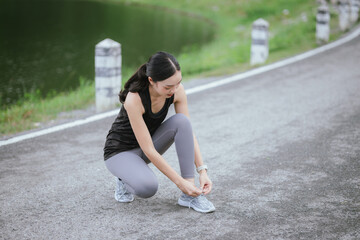 Fototapeta premium A young woman jogs in the city on a summer morning, embodying an active lifestyle. This fit athlete, dressed in sports clothing, enjoys outdoor exercise, promoting health, vitality, and a healthy life