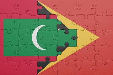 puzzle with the colourful national flag of maldives and flag of east timor .