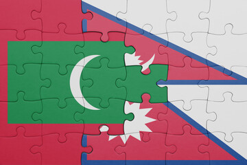 puzzle with the colourful national flag of maldives and flag of nepal .