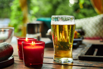 a glass of beer on a wooden table in the garden