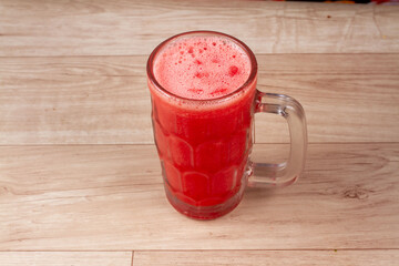 Homemade watermelon juice in glass on wooden background