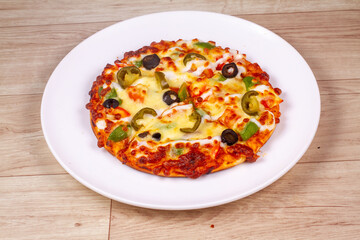 Delicious pizza served on white plate isolated on wooden background