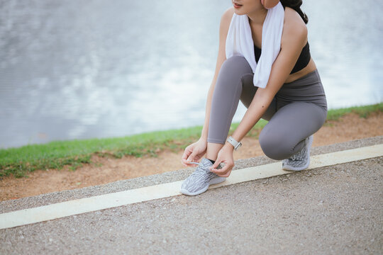 A beautiful woman jogs alone in the city, drinking water. Embracing an active lifestyle, she runs with energy and joy, showcasing fitness, health, and endurance, enjoying the outdoors and nature's bea