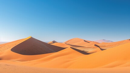 The rolling sand dunes of the Namib Desert in Namibia, with a clear blue sky overhead.