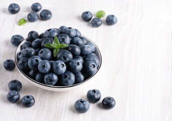 Fresh blueberries on a wooden white table, with copy space for text