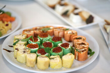 Rolls with cheese and caviar on the buffet table.