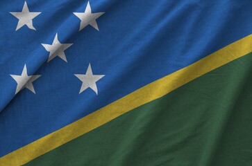 Solomon Islands flag depicted on folded wavy fabric of old cloth close up