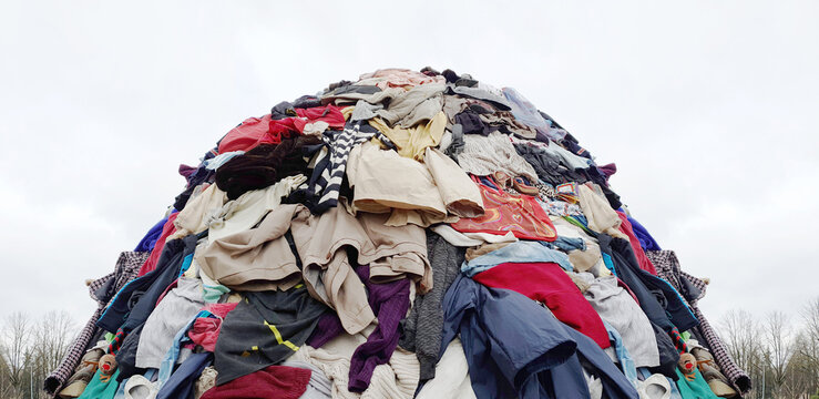 textile pollution, fast fashion industry waste, old clothing cloth fabric garment trash garbage pile stack heap  background, concept of fast fashion industry tax and recycling