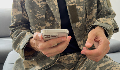 Soldier using a mobile phone against white background