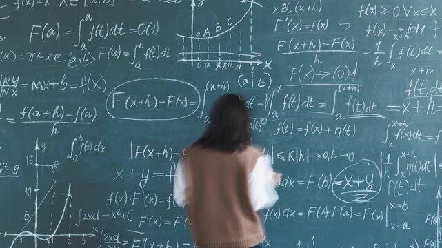 Time lapse of woman mathematician writing formula on chalkboard focused on science development in college. Education and research concept.