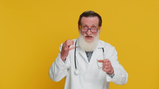 Excited amazed senior doctor cardiologist man showing with hands brain head explosion gesture, solution, inspiration, success brainstorm. Apothecary pharmacy grandfather isolated on yellow background