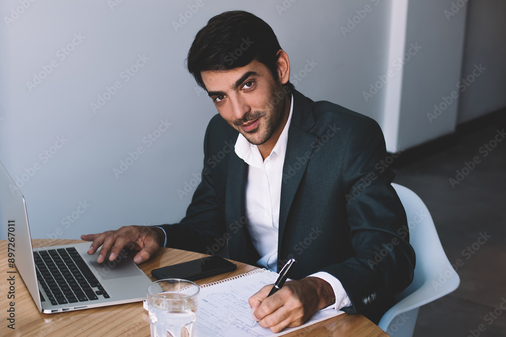 Aufkleber portrait of smiling male graphic designer creating logotyp for company via laptop device and writing