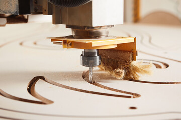 Numerically controlled woodworking machine cuts rounded complex lines on the canvas. Computer...