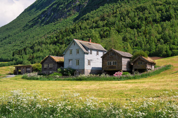 Old wooden farm buildings, nestled into a norwegian mountainside, along one of the spectackuar...