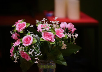 Beautiful pink artificial flowers in a vase on the table