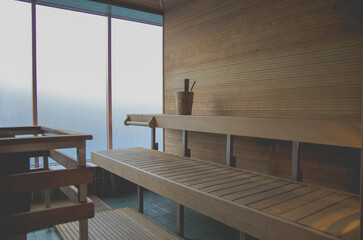 Finnish or dry sauna with oceanview or view of the sea inside male locker room of spa or wellness...