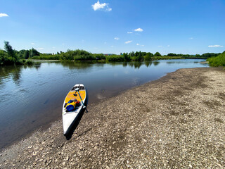 Enjoy tranquil relaxation on a serene river with a paddleboard under a sunny sky, surrounded by...